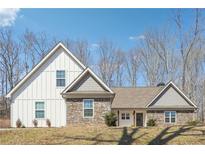Charming new construction home featuring stone and white siding, complemented by mature trees and a bright blue sky at 40 Oak Forest Dr, Oxford, GA 30054