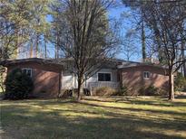 Charming single-story brick home with front porch and mature trees providing ample shade at 974 Clydesdale Dr, Marietta, GA 30062