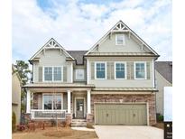 Charming two-story home with stone accents, a welcoming porch, and a two-car garage at 1760 Grand Oaks Drive, Woodstock, GA 30188