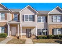 Charming townhome with neutral siding, black shutters and tidy landscaping creating a welcoming curb appeal at 2258 Bigwood Trail Trl, Atlanta, GA 30349