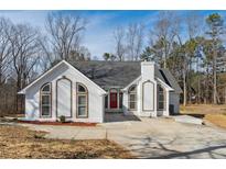 Charming single-story home with a red front door and a well-maintained front yard at 8026 Rivermont Ct, Snellville, GA 30039