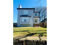 Charming two-story home with light blue siding and a well-manicured lawn at 900 Ira Sw St, Atlanta, GA 30310