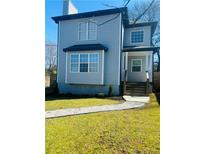 Charming two-story home with light blue siding, a walkway, and a well-manicured lawn at 900 Ira Sw St, Atlanta, GA 30310