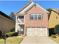 Charming brick home featuring a well-maintained lawn and a two-car garage at 2016 Barberry Dr, Buford, GA 30519