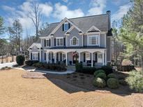Beautiful two-story home featuring a large front porch, classic shutters, and well-manicured landscaping at 118 Savanna Estates Dr, Canton, GA 30115