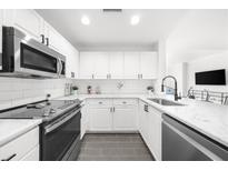 Modern kitchen with stainless steel appliances, white cabinets, and marble countertops at 3475 Oak Valley Ne Rd # 410, Atlanta, GA 30326