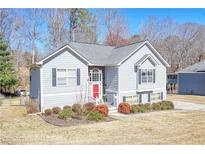 Charming two-story home with gray siding, dark shutters, a red front door, and neatly manicured landscaping at 4046 Harvest Ridge Dr, Douglasville, GA 30135
