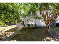 Charming two-story townhome featuring a walkway up to the front door and mature shade trees at 215 Odyssey Turn, Conyers, GA 30012