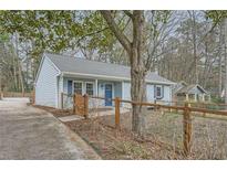 Charming single-story home featuring light blue siding, a well-manicured front yard, and a welcoming blue front door at 738 S Candler St, Decatur, GA 30030