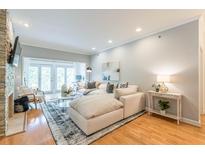 Bright living room with large sectional sofa, stone fireplace, and access to outdoor balcony at 2865 Lenox Road Ne # 602, Atlanta, GA 30324