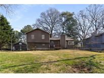 Traditional home featuring a brown exterior, a detached garage, and a spacious front yard at 4223 Mountain Glen Trce, Snellville, GA 30039