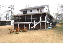 Expansive backyard featuring a screened porch, stairs, and a charming seating area with wooden chairs at 4040 Merritt Dr, Cumming, GA 30041
