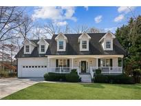 Charming home featuring dormer windows, a covered porch, and well-manicured front lawn at 1283 Hada Ct, Lawrenceville, GA 30043