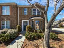 Charming two-story townhome featuring a brick facade and a well-manicured front yard at 11403 S Grove Dr, Hampton, GA 30228