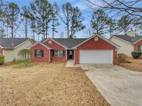 Charming single-story brick home with attached two-car garage and well-kept front yard at 1681 Graystone Dr, Hampton, GA 30228