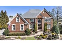 Beautiful two-story brick home with manicured landscaping and symmetrical design at 4235 Iron Duke Ct, Peachtree Corners, GA 30097