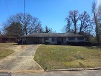 Charming single-story home with a carport and a well-maintained front yard and driveway at 2374 Woodcastle Se Ln, Atlanta, GA 30316