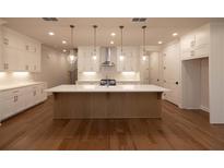 Bright, modern kitchen boasts a large center island, stainless appliances, and ample cabinet space at 133 Ward'S Crossing Way # 18, Johns Creek, GA 30022