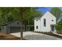 Modern home featuring a white exterior, gray garage, and a concrete driveway at 145 Cedarwood Ln, Roswell, GA 30075
