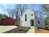 Modern farmhouse exterior with white siding, red garage, and a connecting covered walkway at 145 Cedarwood Ln, Roswell, GA 30075