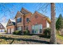 Charming two-story brick home with a well-manicured lawn and attached two-car garage at 1490 Fair Point Pass, Suwanee, GA 30024