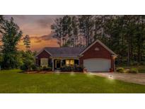 Charming brick home with well-manicured lawn and inviting curb appeal at sunset at 25 Horseshoe Ct, Covington, GA 30014
