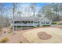 Charming home featuring a welcoming front porch and well-maintained landscaping in a wooded surrounding at 1980 Two Springs Way, Lawrenceville, GA 30043