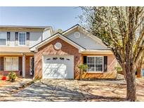 Charming brick home featuring a one-car garage and blossoming tree at 2139 Hickory Se Bnd # E, Conyers, GA 30013