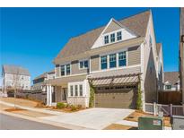 Beautiful two-story home with a two-car garage and a well-manicured lawn on a clear and sunny day at 906 Bingham St, Woodstock, GA 30188