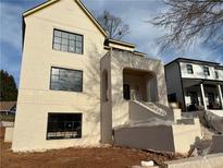 Newly constructed, two-story cream-colored home with large black framed windows and arched porch at 1366 Wessyngton Ne Rd, Atlanta, GA 30306