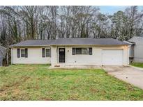 Charming single-story home with a well-maintained lawn and attached single car garage at 1492 Cobb Branch Dr, Decatur, GA 30032