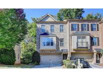 Charming brick townhome featuring an attached two-car garage and manicured front yard at 2790 Laurel Valley Trl, Buford, GA 30519