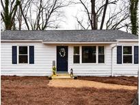 Charming single-story home with a white exterior, dark shutters, and a welcoming front door with floral wreath at 3601 Orchard Cir, Decatur, GA 30032