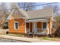 Charming orange cottage-style home with a welcoming front porch and well-maintained landscaping at 224 Carroll Se St, Atlanta, GA 30312