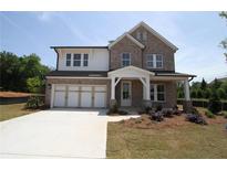 Inviting two-story brick home with a two-car garage and classic architectural details at 206 Wild Ginger Bend, Woodstock, GA 30188