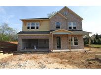 Two-story home with brick and siding exterior, open garage, and covered porch, in mid-construction phase at 206 Wild Ginger Bend, Woodstock, GA 30188
