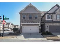 Charming two-story home with gray brick and two-car garage, set in a suburban neighborhood at 8605 Gladden Ln, Suwanee, GA 30024