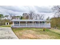 Charming home featuring a welcoming front porch, complemented by a well-maintained lawn and a storage shed at 10 Creek Se Dr, Cartersville, GA 30121