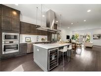 Bright kitchen features a large island with cooktop, wine fridge, stainless appliances, and dark wood cabinets at 241 Maynard Se Ter # 15, Atlanta, GA 30316