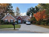 Charming one-story home with a brick-accented entry, mature trees, and a well-manicured lawn at 672 Loral Pines Ct, Lawrenceville, GA 30044
