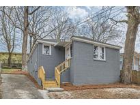 Charming one-story home with gray brick exterior, new wooden stairs and mature trees at 403 Westchester Nw Blvd, Atlanta, GA 30314