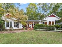 Charming home featuring a well-manicured lawn and a welcoming front porch with cozy seating at 6791 Yacht Club Dr, Acworth, GA 30102