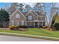 Charming two-story brick home with well-manicured lawn and inviting front porch, a perfect suburban oasis at 406 Greyfield Dr, Canton, GA 30115