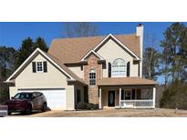 Charming two-story home featuring a front porch, attached garage, and stone accents at 190 The Falls Blvd, Covington, GA 30016