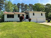 Charming two-story home with manicured lawn and an attached two-car garage at 4034 Weeks Nw Dr, Kennesaw, GA 30144
