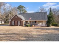 Charming single-story brick home with a covered front porch and well-manicured lawn at 145 Stewart Hollow Ln, Covington, GA 30016