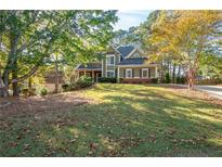 Charming two-story home with mature trees and a well-maintained front yard at 4711 Oakleigh Manor Dr, Powder Springs, GA 30127