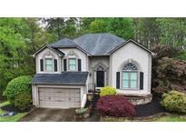 Charming two-story home with a well-maintained lawn, lush landscaping, and an attached two-car garage at 5730 Paces Pl, Suwanee, GA 30024