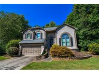 Charming two-story home with a well-maintained lawn and lush landscaping and attached two car garage at 5730 Paces Pl, Suwanee, GA 30024