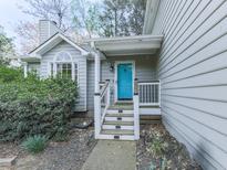 Charming home featuring a covered front porch and a bright blue front door, and landscaped yard at 3623 Spring Meadow Ct, Acworth, GA 30101